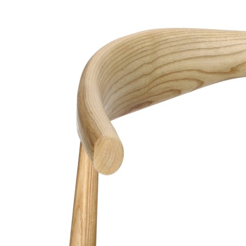 Zbliżenie na rzeźbiarskie, gięte oparcie krzesła Kibo wykonane z naturalnego jesionu.