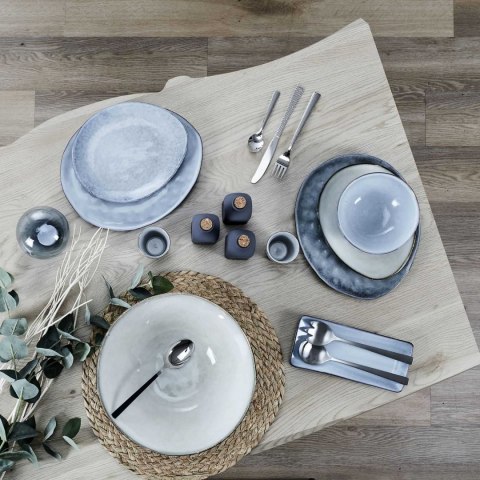 Ceramiczna miska japandi Midori II pośród szarych talerzy i sztućców na drewnianym stole, widok z góry.